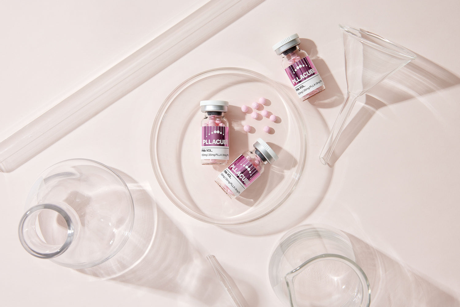 PLLACUBE PiNk VOL PLLA + PN skinbooster vials displayed with lab glassware, demonstrating professional-use formulation for skin hydration, elasticity, and radiance