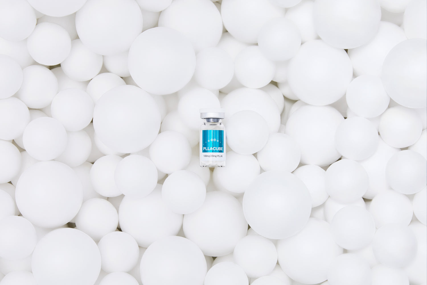 PLLACUBE vial displayed on multi-porous INCUBE™ material spheres, representing fast-dissolving cosmetic formulation technology for professional use